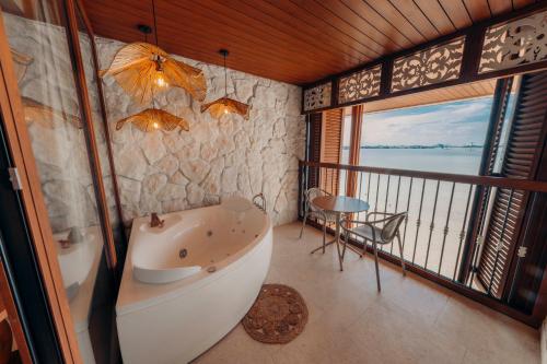 a bathroom with a bath tub and a balcony at Hotel Rio Guayas by Art Hotels in Guayaquil