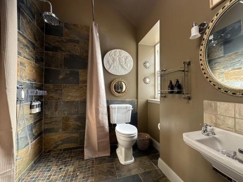 a bathroom with a toilet and a shower and a sink at Barns Studio in Peebles