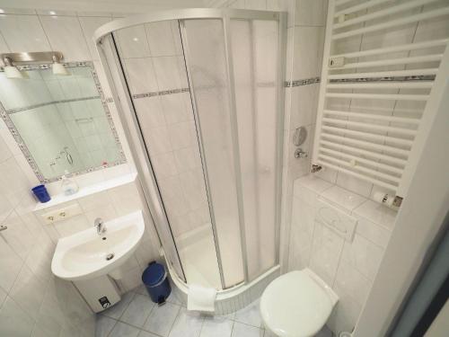a bathroom with a shower and a toilet and a sink at Appartement-124 in Westerland