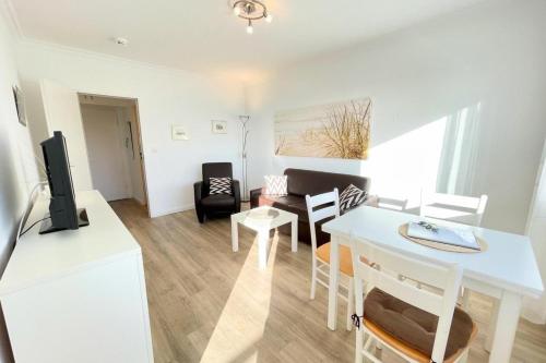 a living room with a white table and a dining room at Appartement-162 in Westerland