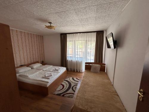 a small bedroom with a bed and a window at Casa Bașu in Băile Herculane