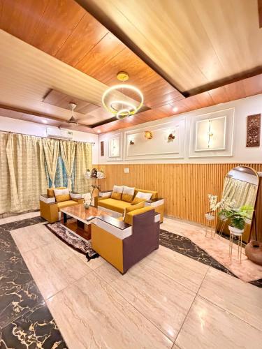 a living room with a couch and a table at Luxury Palm Stay in Jammu
