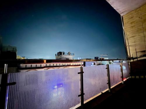 a fence on top of a building at night at Luxury Palm Stay in Jammu