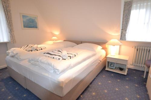 two beds in a hotel room with white sheets at Haus-Neumann in Westerland