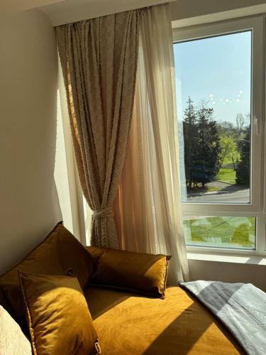 a bed in front of a window with a view at AURA BEACH apartment in Burgas
