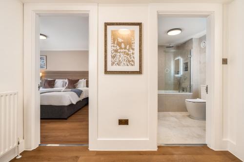 a bedroom with a bed and a bathroom at Monarch House - Serviced Apartments - Kensington in London