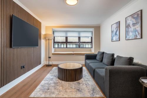 a living room with a couch and a table at Monarch House - Serviced Apartments - Kensington in London