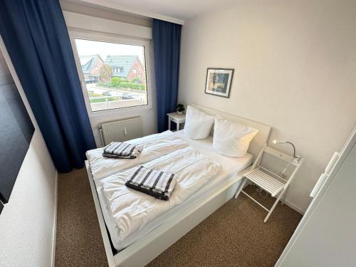 a small bedroom with a bed and a window at Ferienwohnung-20-A139 in Westerland