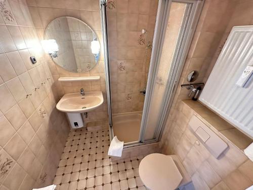 a bathroom with a sink and a toilet and a shower at Ferienwohnung-20-A139 in Westerland