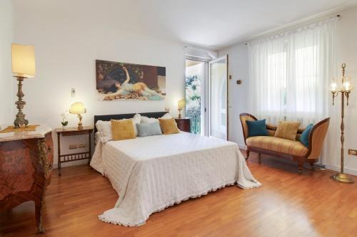 a bedroom with a large white bed and a fireplace at Villa Alberta With Reserved Beach Spot in Marina di Massa