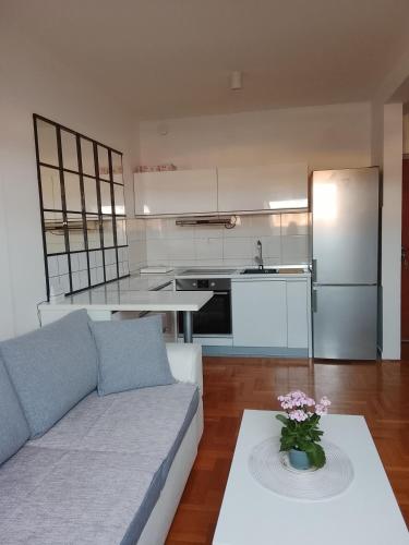 a living room with a couch and a kitchen at Apartman Skyview in Požarevac