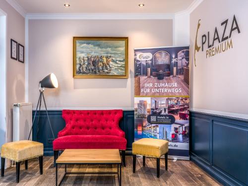 ein roter Stuhl in einem Raum mit Postern in der Unterkunft PLAZA Premium Sylt in Wenningstedt-Braderup