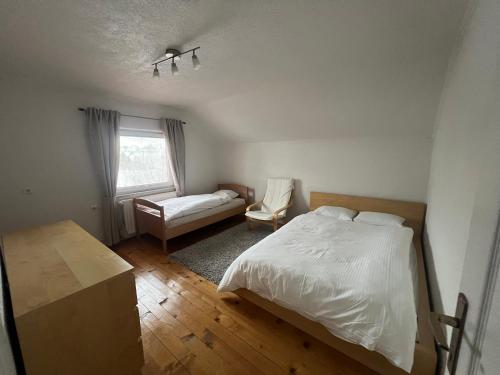 a bedroom with a bed and a chair and a window at Kuća za odmor IVKOVIĆ in Kupres