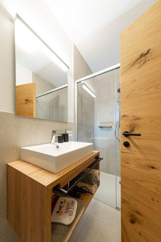 a bathroom with a white sink and a shower at Pension Hofer in Brunico