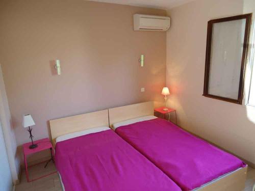 a bedroom with a large bed with purple sheets at Delaporte in Béziers