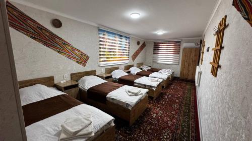 a group of beds in a room with a roomthritisthritisthritisthritisthritisthritis at Deshon Qala Guest House in Khiva