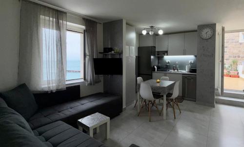 a living room with a couch and a table and a kitchen at Lili's Sea View in Budva
