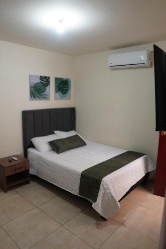 a bedroom with a bed and a nightstand next to it at Casa Esperanza in Cali