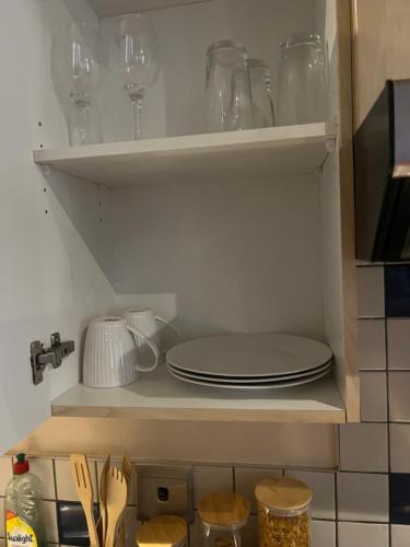 a cupboard with plates and wine glasses in it at Warm & Cozy Diamonds Hotel in Johannesburg