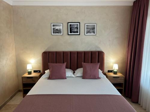a bedroom with a large bed with two nightstands and two lamps at VAMA 25- Vama Veche in Vama Veche