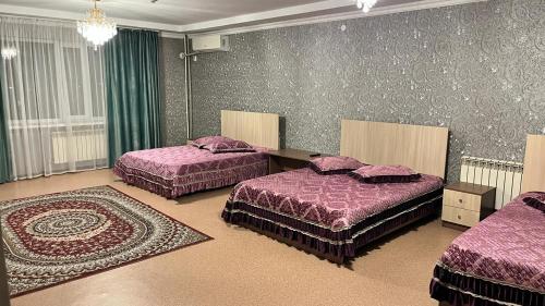 a bedroom with two beds and a rug at Акерке Балхаш in Balqash
