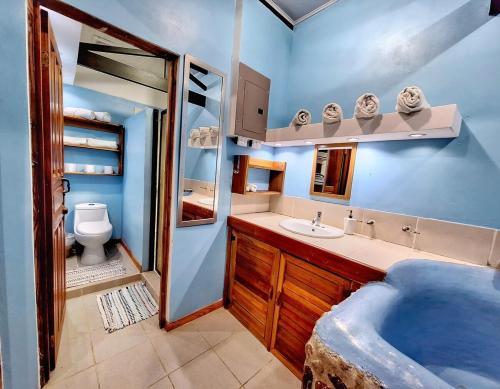 a blue bathroom with a tub and a sink at Ocean Breeze Beach Front Apartment with AC in Puerto Viejo
