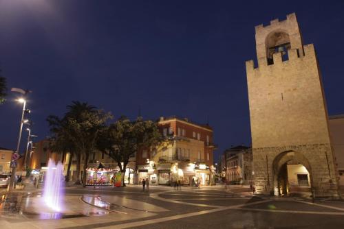 a city street with a clock tower at night at Hotel Mistral in Oristano