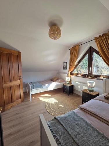 a bedroom with two beds and a window at Jagodowa Czulnia in Zwierzyń