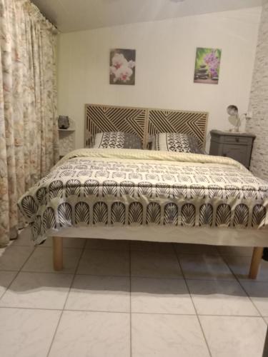a bedroom with a bed with a blanket on it at gite du guip in Trégourez