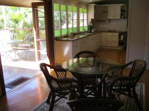 uma cozinha com uma mesa de vidro e cadeiras e uma mesa em Classique Bed & Breakfast em Townsville
