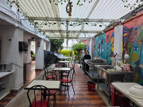 a restaurant with tables and chairs and graffiti on the wall at Anys Hostal in Mexico City
