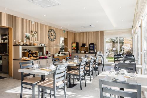 a restaurant with tables and chairs in a room at Hôtel de France Contact-Hôtel in Évian-les-Bains