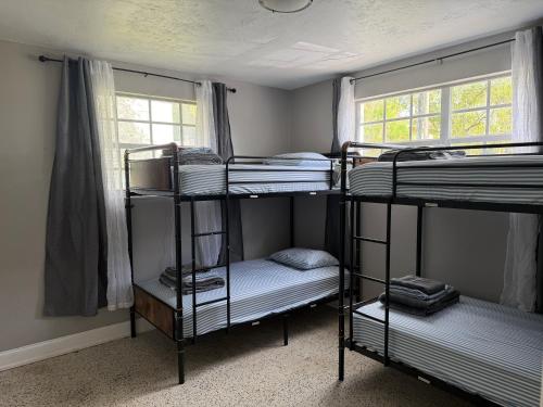 a room with three bunk beds and a window at Bek's Hostel in Hallandale Beach