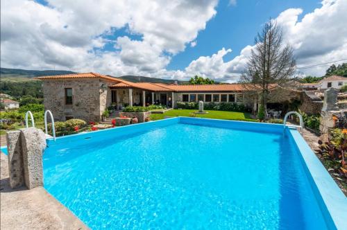 a swimming pool in front of a house at Casa de Alderete in Valença