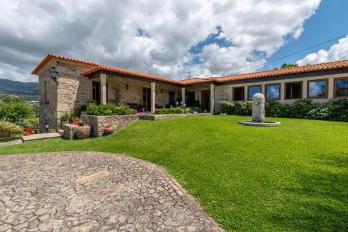 a house with a green lawn in front of it at Casa de Alderete in Valença