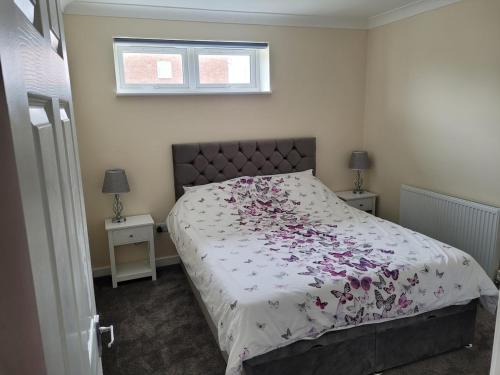 a bedroom with a bed with a floral bedspread at Pebble Beach, ground floor 1 bedroom flat in Chichester