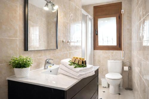a bathroom with a sink and a toilet and a mirror at villa PLAYA RUSTICAL in Miami Platja