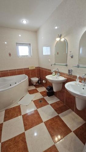 a bathroom with two sinks and a tub and a toilet at Hradna 9a in Nové Zámky