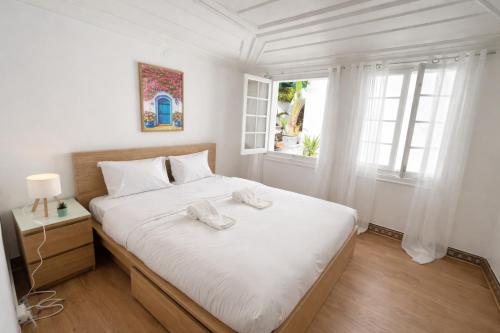 a bedroom with a white bed and a window at Relax Guesthouse & Hostel Lagos Central in Lagos