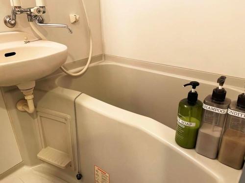 a bathroom with a sink and a white bath tub at AO Dazaifu / Vacation STAY 61718 in Chikushino