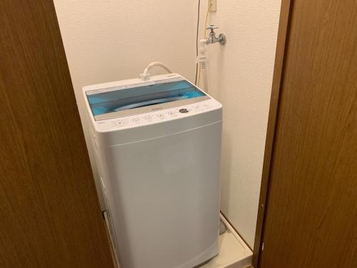 a small white refrigerator in a corner of a room at AO Dazaifu / Vacation STAY 61718 in Chikushino