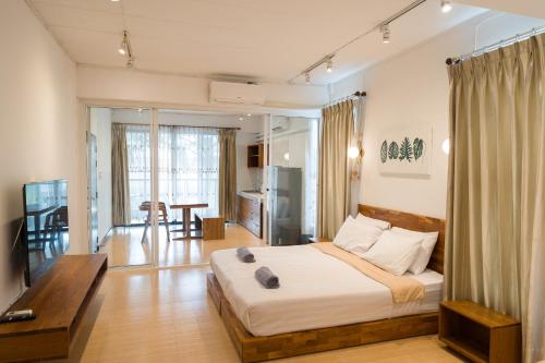a bedroom with a bed and a living room at Chiang Mai Mansion 2 in Chiang Mai