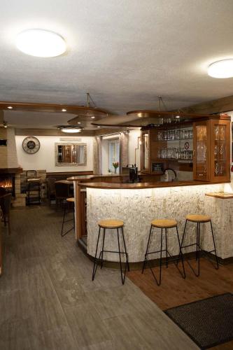 a kitchen with a bar and some stools at Chata Na Pasekách in Rajnochovice