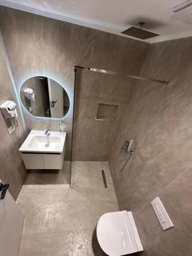 a bathroom with a sink and a toilet and a mirror at Logan Rooms Berat in Berat