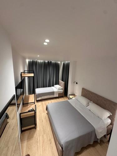 a hotel room with two beds and a window at Logan Rooms Berat in Berat