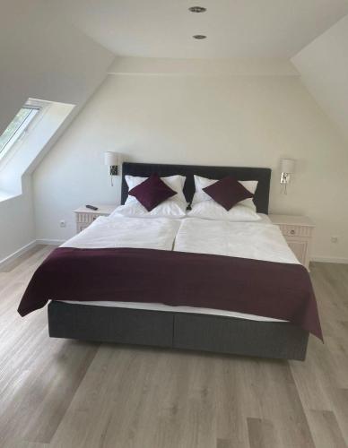 a bedroom with a large bed with white sheets and pillows at Seaside-Amrum-16 in Norddorf