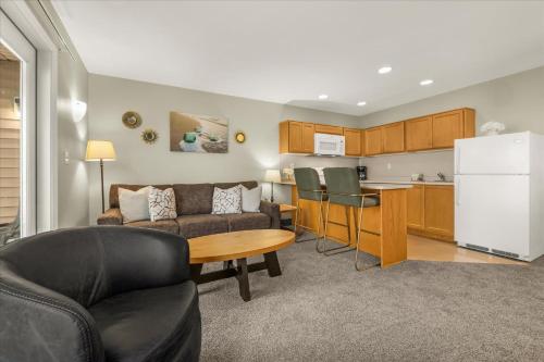 a living room with a couch and a table and a kitchen at Oceanfront King Suite - Beach Access - Pool and Hot Tub in Lincoln City