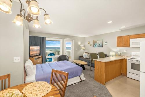 a living room and a kitchen with a bed and a table at Oceanfront King Suite - Beach Access - Pool and Hot Tub in Lincoln City
