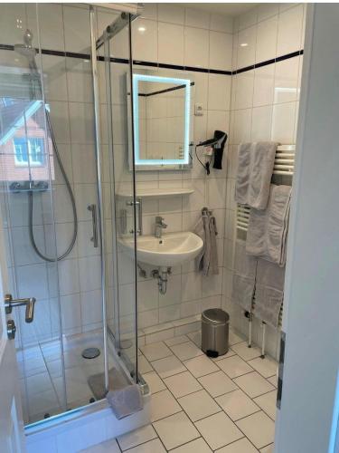 a bathroom with a glass shower and a sink at Seaside-Amrum-14 in Norddorf