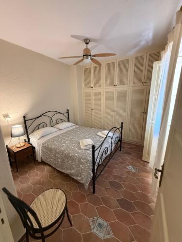 a bedroom with a bed and a ceiling fan at PALIO LIMANI APARTMENTS in Spetses